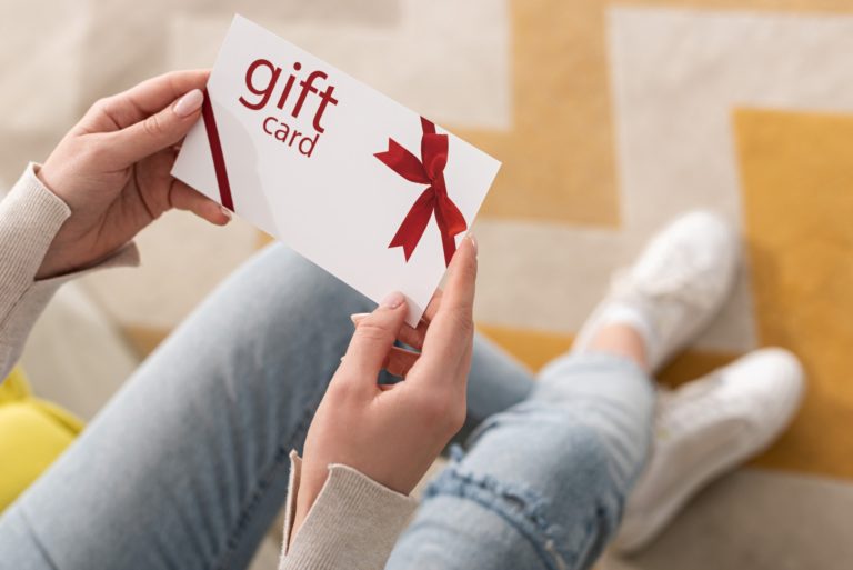 Person holding red-ribbon gift card